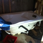 Tub set in place temporarily and setting up the water drainage piping.