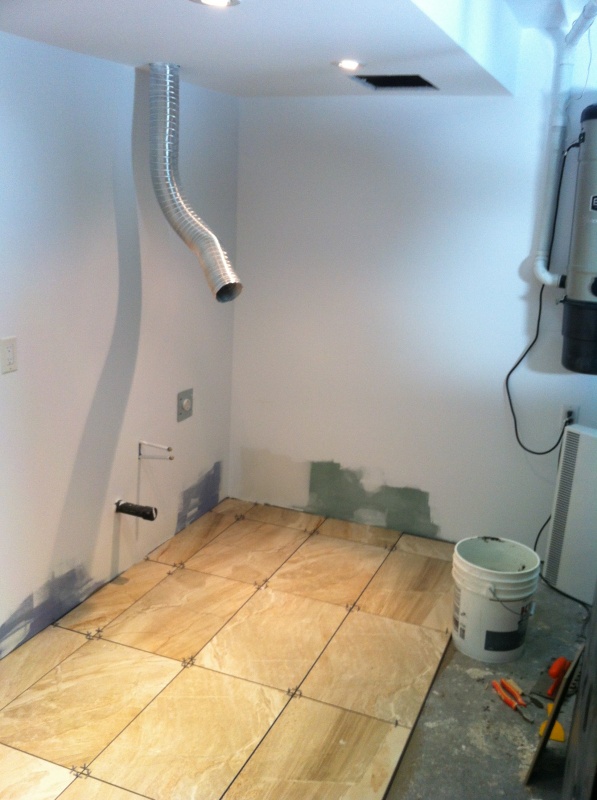 Putting in the new ceramic for the laundry room area.